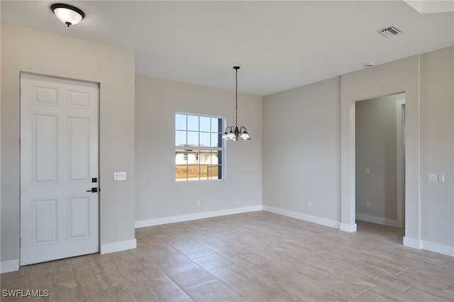 spare room with an inviting chandelier, baseboards, and visible vents