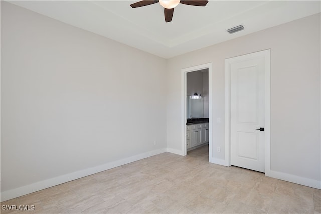 unfurnished bedroom with visible vents, baseboards, ensuite bath, and a ceiling fan