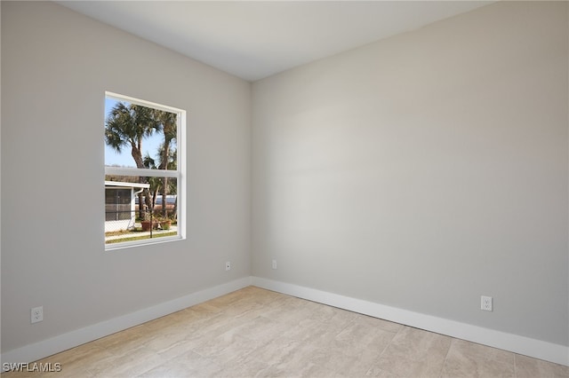 empty room featuring plenty of natural light and baseboards