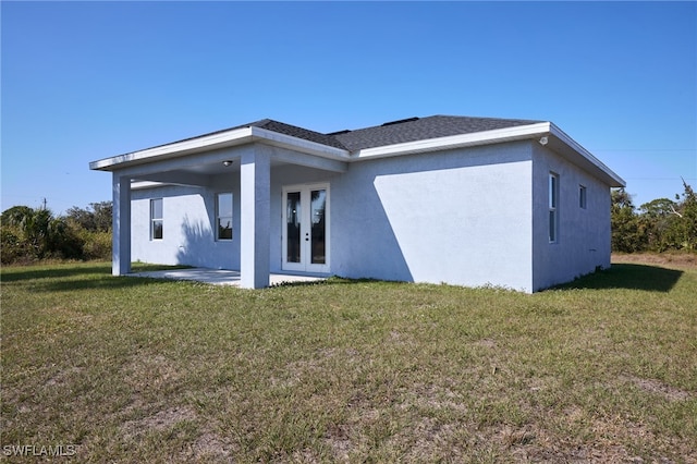 back of house with french doors, a patio, a lawn, and stucco siding