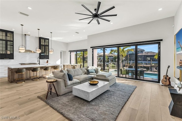 living room with ceiling fan and light wood-type flooring