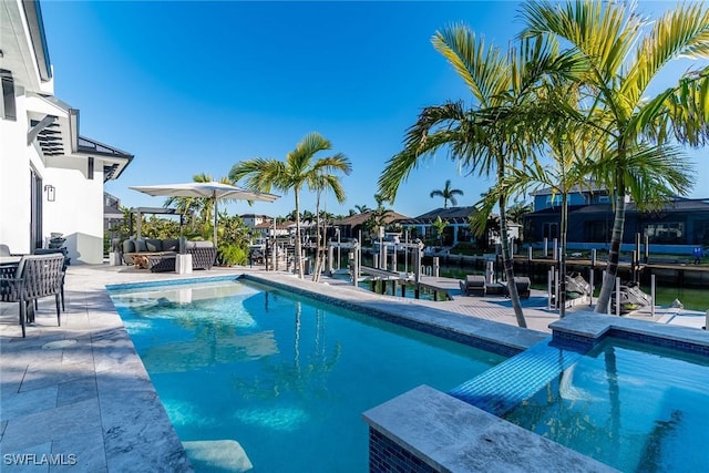 view of pool featuring outdoor lounge area, a water view, and a patio