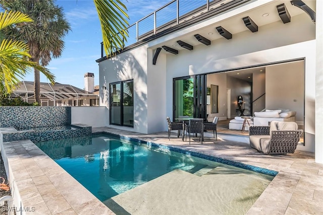 back of house featuring a patio area, a balcony, and an outdoor hangout area