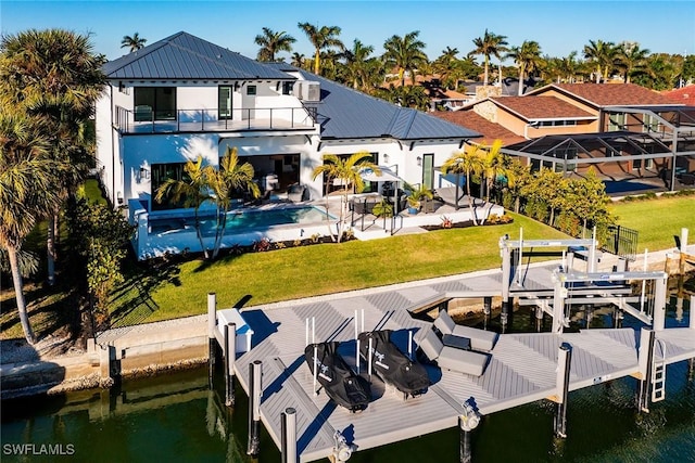 dock area with a balcony, a water view, and a patio