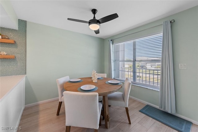 dining space with ceiling fan and light hardwood / wood-style flooring