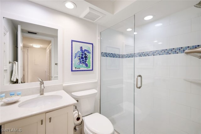 bathroom featuring an enclosed shower, vanity, and toilet