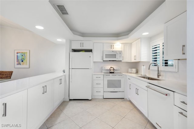 kitchen with white cabinets, white appliances, sink, and light tile patterned floors