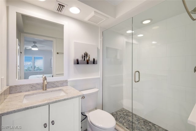 bathroom featuring ceiling fan, a shower with door, vanity, and toilet