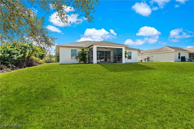 rear view of house featuring a lawn and a sunroom