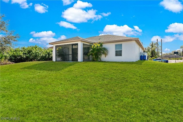 rear view of house with a sunroom and a lawn