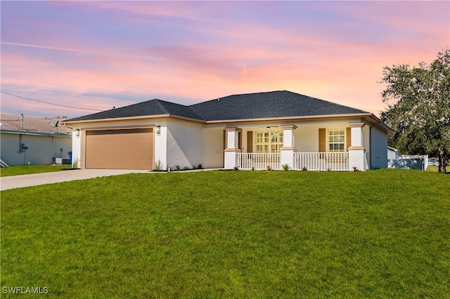 view of front of house featuring a lawn, a garage, and covered porch