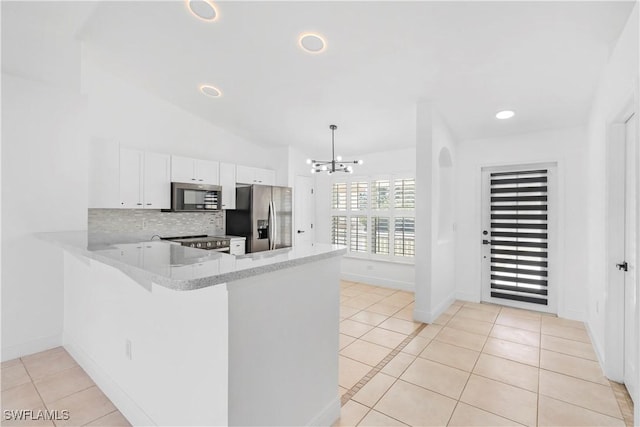 kitchen with white cabinetry, tasteful backsplash, light tile patterned floors, appliances with stainless steel finishes, and kitchen peninsula