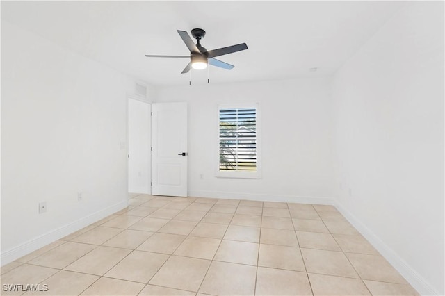 empty room with ceiling fan and light tile patterned floors