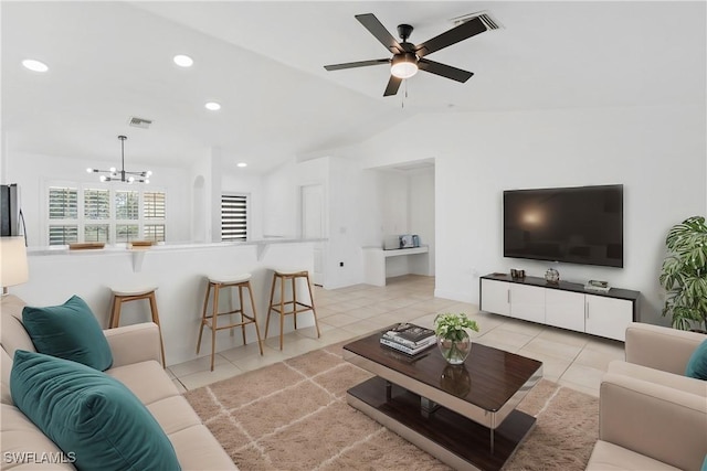 tiled living room with lofted ceiling and ceiling fan with notable chandelier