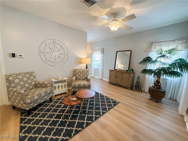 living area featuring hardwood / wood-style floors and ceiling fan