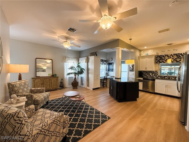 living room with sink, plenty of natural light, light hardwood / wood-style floors, and ceiling fan