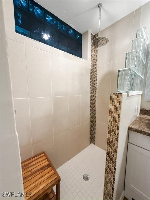 bathroom featuring vanity and tiled shower