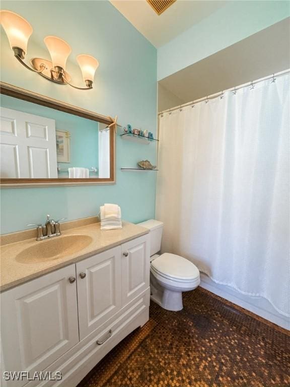 bathroom with vanity, curtained shower, and toilet