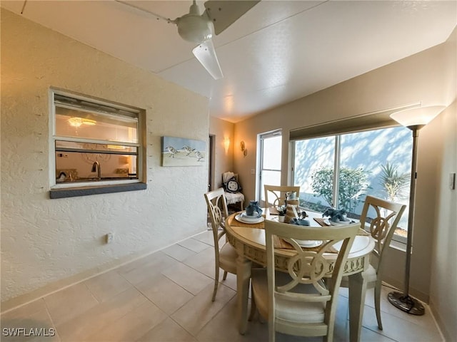 tiled dining space with ceiling fan