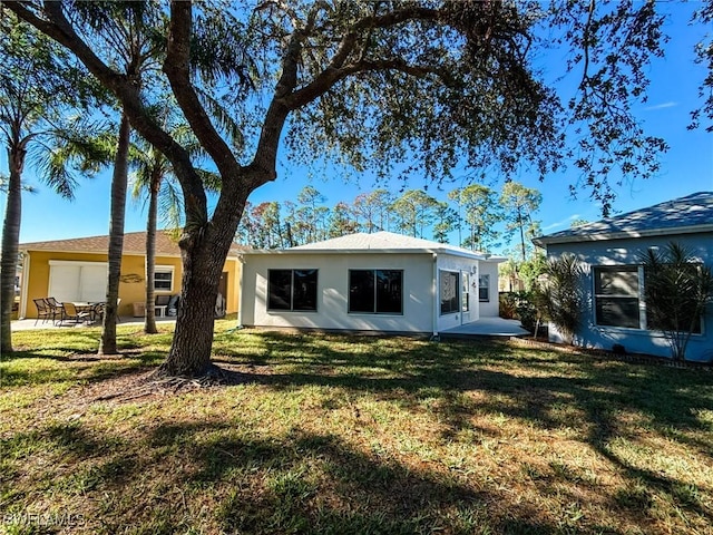 back of house featuring a yard and a patio