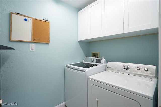 clothes washing area with cabinets and washer and dryer