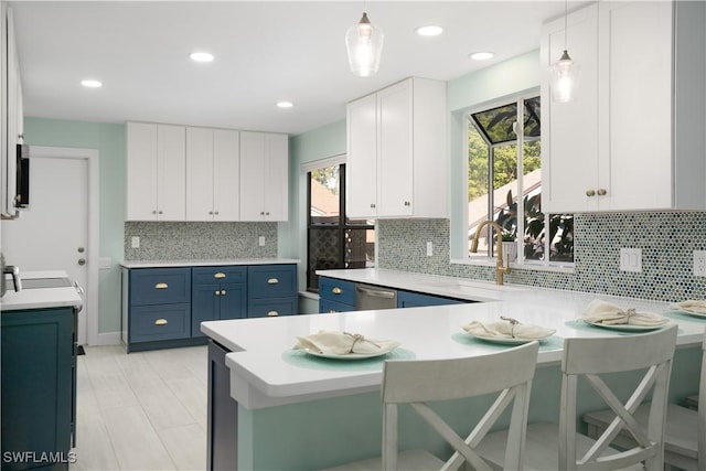 kitchen featuring backsplash, blue cabinetry, pendant lighting, white cabinets, and a breakfast bar area