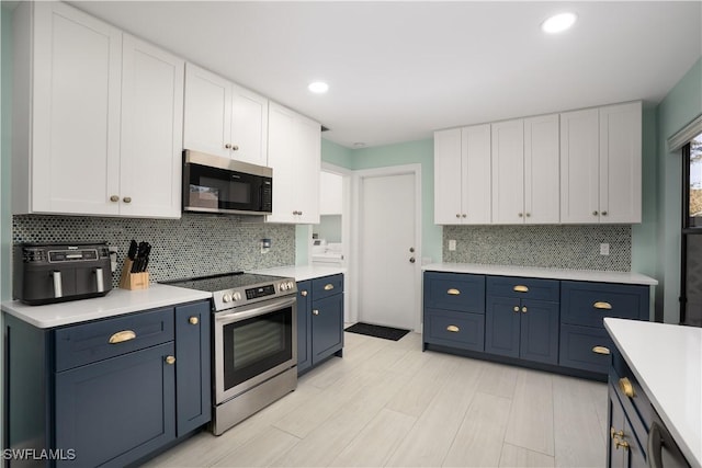 kitchen with blue cabinets, white cabinets, and appliances with stainless steel finishes