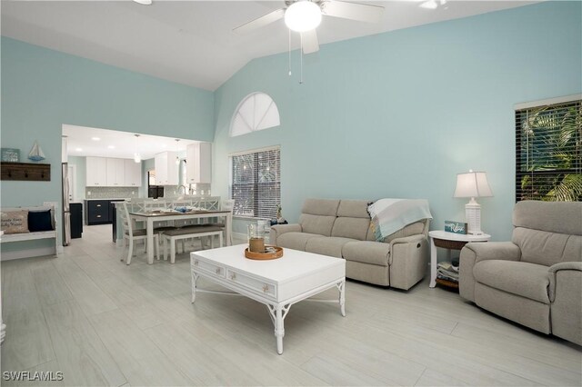 living room featuring high vaulted ceiling and ceiling fan