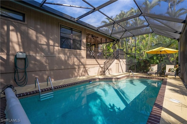 view of swimming pool with a lanai and ceiling fan