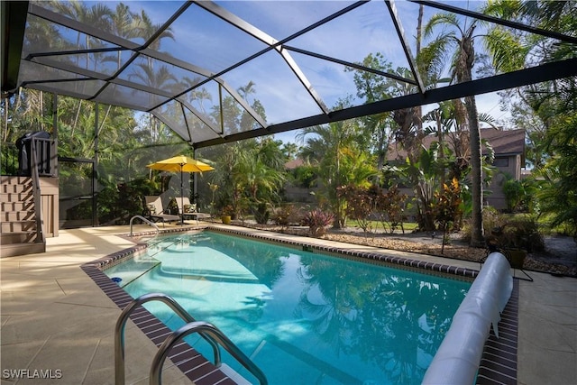 view of swimming pool featuring glass enclosure and a patio