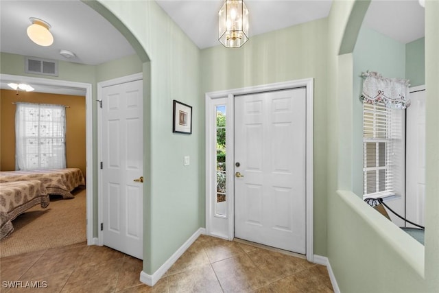 tiled foyer featuring a chandelier