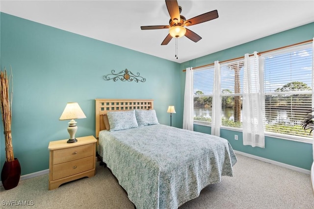 carpeted bedroom featuring multiple windows and ceiling fan