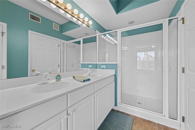 bathroom featuring tile patterned flooring, vanity, and a shower with shower door