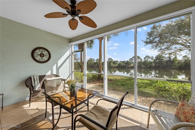 sunroom featuring a water view and ceiling fan