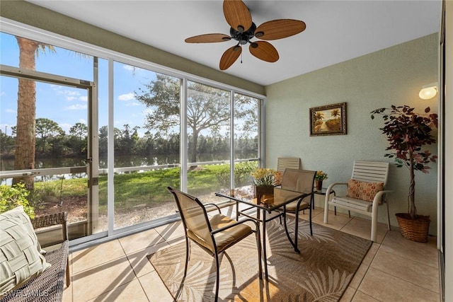 sunroom featuring ceiling fan and a water view