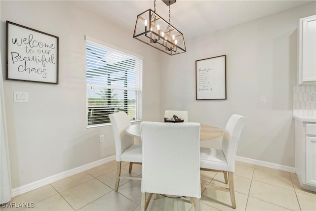 tiled dining room with an inviting chandelier