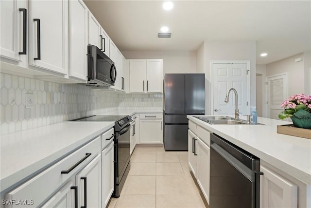 kitchen featuring white cabinetry, sink, decorative backsplash, light tile patterned floors, and black appliances