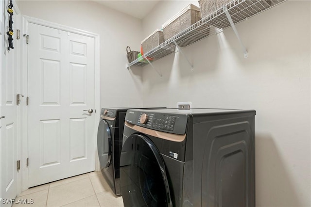 washroom with washing machine and clothes dryer and light tile patterned flooring