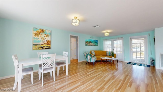 dining space with light hardwood / wood-style flooring and french doors