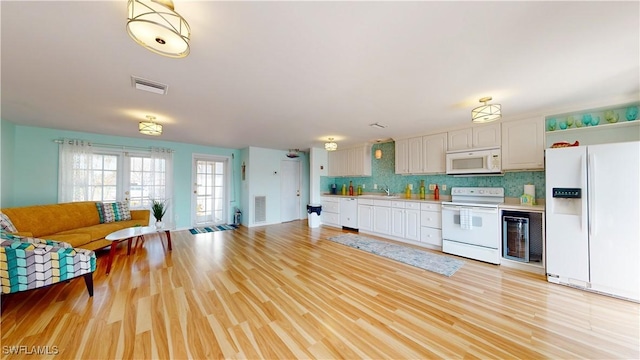 kitchen featuring backsplash, french doors, white appliances, and light wood-type flooring