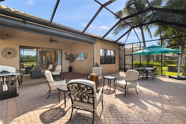 view of patio with a lanai, grilling area, and ceiling fan