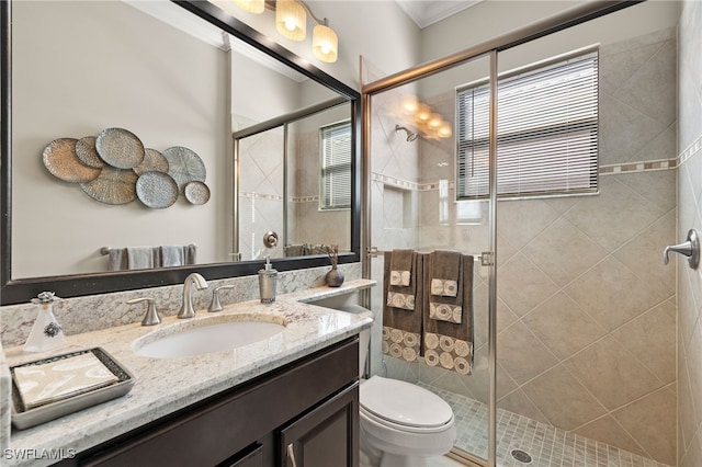 bathroom with a shower with shower door, toilet, and vanity