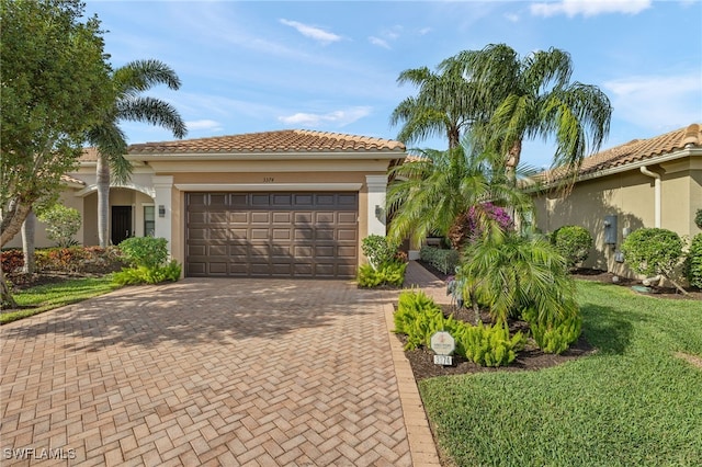 mediterranean / spanish house featuring a front yard and a garage