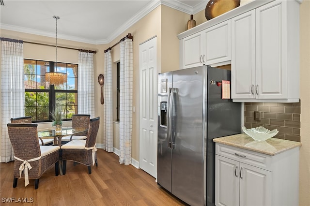 kitchen featuring decorative backsplash, decorative light fixtures, white cabinets, and stainless steel fridge with ice dispenser