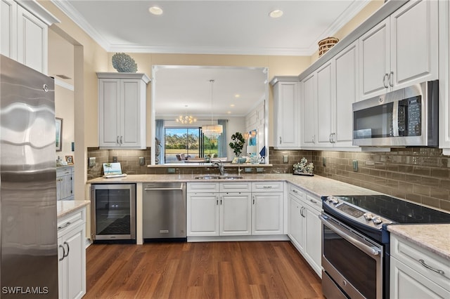 kitchen with pendant lighting, beverage cooler, white cabinetry, stainless steel appliances, and sink