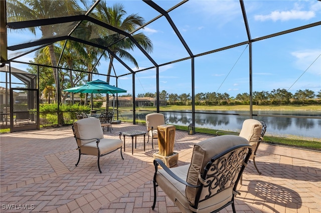 view of patio featuring glass enclosure and a water view