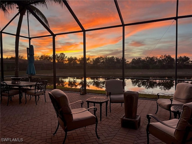 patio terrace at dusk with a lanai and a water view