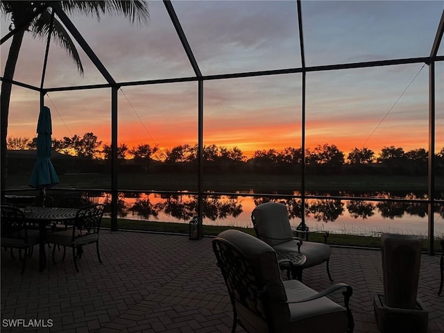 patio terrace at dusk with a water view and a lanai