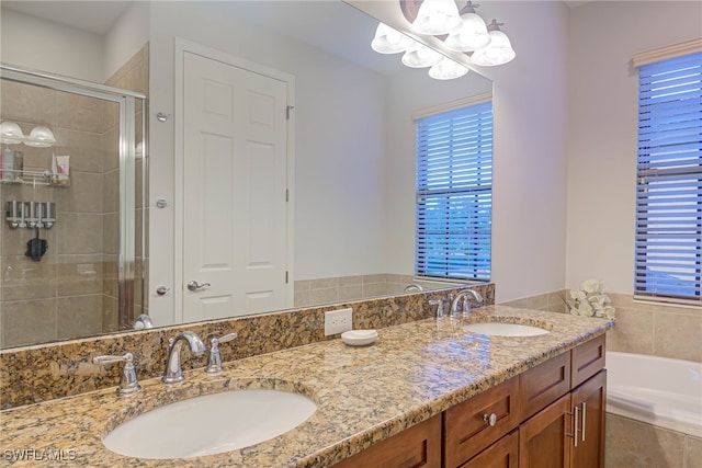 bathroom featuring vanity, plus walk in shower, and a chandelier