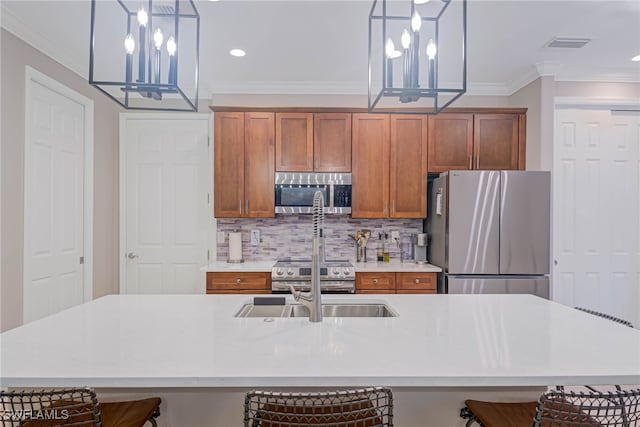 kitchen with a kitchen breakfast bar, pendant lighting, and stainless steel appliances